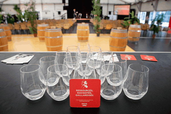 gros plan sur des verres et sur le dessous de verre Brive Tourisme avec la salle en fond