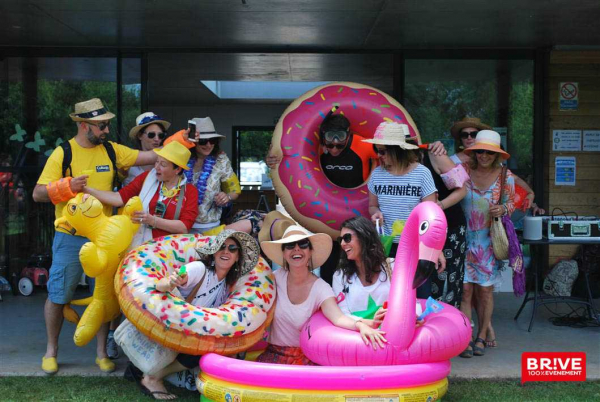 Groupe de personnes avec des bouées flamants roses et donuts