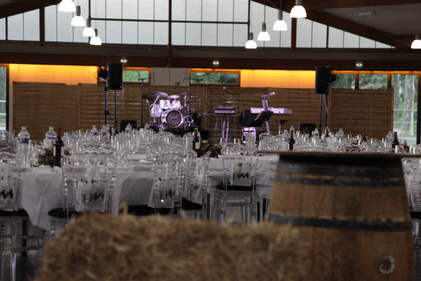 Salle avec des tables blanches et une scène de musique vide