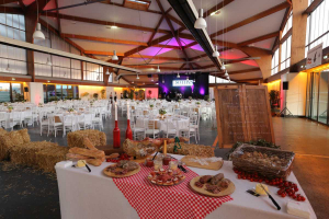 Salle remplie de tables et chaises avec une table pleine de produits du terroir en premier plan